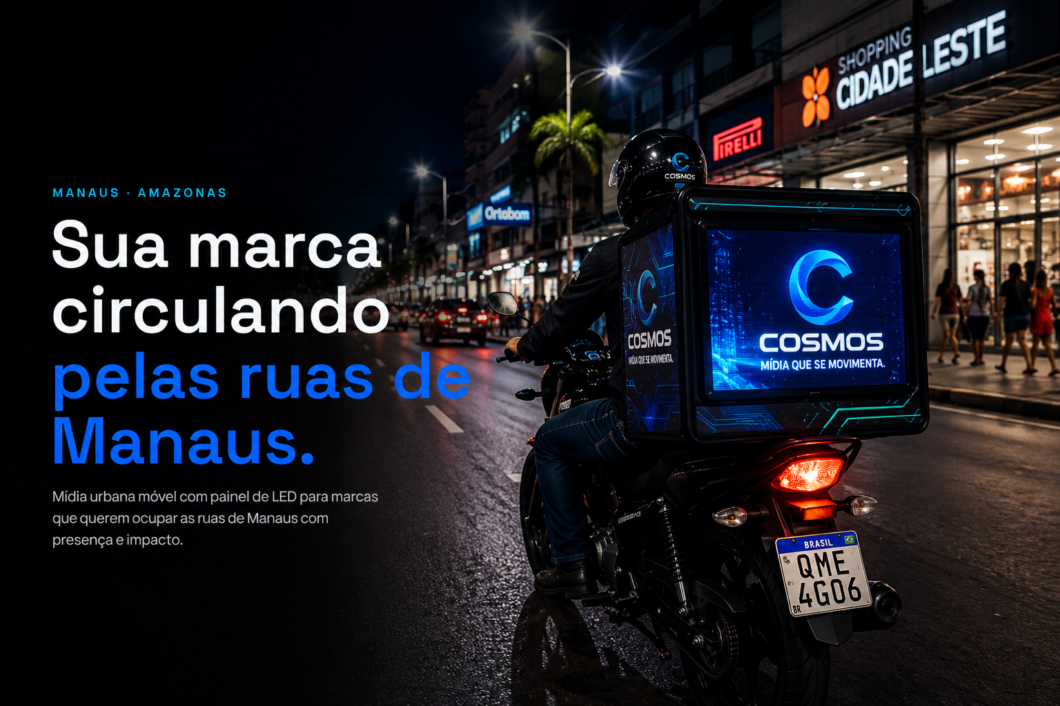 Moto COSMOS com painel de LED iluminado circulando à noite por uma avenida comercial de Manaus